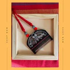 A unique necklace made from an upcycled wooden comb, hand-painted with a black and white bird motif inspired by Madhubani art. This is wearable art that tells a story of transformation.