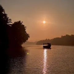 The beauty of nature during a boat ride in Honnavar, with the sun setting over the calm backwaters.