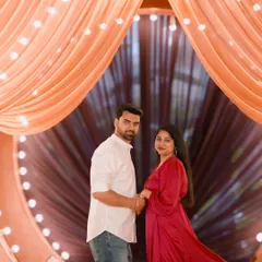 A dramatic and romantic pose under a beautifully draped and lit archway. The warm lighting creates an intimate and magical setting for this pre-wedding photo.