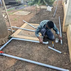 A team member assembles the PVC pipes and fittings for the irrigation system before placing them in the trenches.