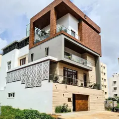 This is a completed residence in AECS Layout, showcasing a powerful contemporary elevation. The design features a prominent wood-clad cube, natural stone at the base, and delicate jalli screens, demonstrating my approach to using mixed materials for texture and character.