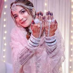 This bride looks like she's stepped out of a fairytale in her shimmering pink lehenga. The makeup is soft and romantic, with a focus on glowing skin and eyes that sparkle.