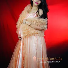 This peach satin gown, paired with a matching ruffled shrug, offers a unique and glamorous option for a studio maternity shoot. The soft fabric and warm color create a beautiful, glowing effect.