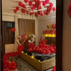 Here is another example of a full room anniversary surprise. I filled the space with red balloons, including a large heart-shaped foil balloon and a silver number '3' to celebrate their special day. The goal is to make the entire room feel like a celebration.
