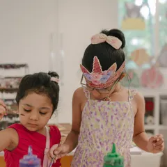 Two young artists, one wearing a unicorn crown, are completely focused on their painting project. Our parties are designed to be engaging, letting kids dive into their creativity and have a blast.