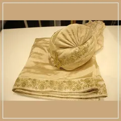 An elegant off-white pagri and matching stole with delicate gold embroidery. These accessories are designed to perfectly complement our sherwanis.