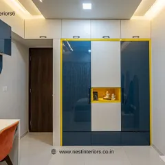The wardrobe in this kid's room features a bold color-block design in blue, white, and yellow. The small niche in the center is perfect for displaying favorite toys or treasures.