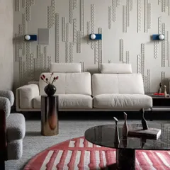 In the living area of Scarlet Horizon, we adorned the walls with custom paneling inspired by jewelry design. This intricate, vertical composition adds visual depth and an ornamental quality, balanced by the soft textures of the cream sofa and the bold, striped rug.