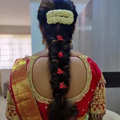 A simple yet beautiful bridal braid. This style uses a mix of jasmine and small red flowers for a touch of colour, paired with a neat bun.