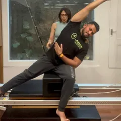 A graduate of our PAI Reformer Instructor course demonstrates his skills, showcasing the strength and knowledge gained through our training.