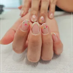 A delicate and feminine design perfect for any occasion. This nail art features tiny, colorful flowers scattered across the tips with a hint of glitter for a subtle sparkle.