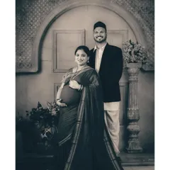 This regal maternity portrait is given a timeless quality with classic monochrome toning. The black and white finish enhances the textures of the traditional attire and the elegance of the vintage studio setting.