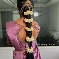 A beautiful fishtail bubble braid, a modern and elegant hairstyle for a traditional event. It's adorned with jasmine flowers for that classic South Indian touch.