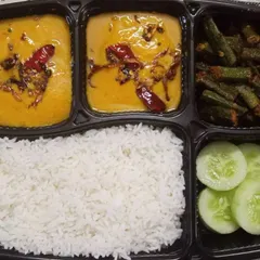 A simple yet delicious vegetarian meal featuring plain rice, dal tadka with a tempering of red chillies, crispy bhindi fry, and a side of cucumber. This is comfort food at its best.