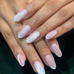 Like a galaxy on your fingertips. This elegant look features a shimmery white cat eye effect that creates a beautiful, celestial glow on long, oval-shaped nails.