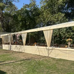 A long shot of our clean and elegant buffet setup for a daytime garden event. The simple, draped counter allows the natural beauty of the surroundings to shine, perfect for a sophisticated outdoor gathering.