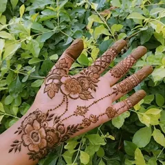 This design features a beautiful floral chain, or 'bel', that gracefully adorns the hand. The greenish-brown color is the natural shade of my fresh henna paste before it dries and stains the skin.
