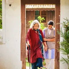 A close-up of a therapist providing gentle, supportive assistance to an elderly guest. This image embodies the compassion and dedication of our entire team.