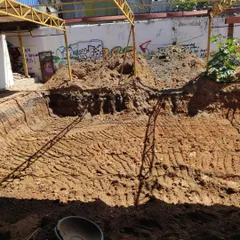 A photo from the early days of construction, showing the ground being dug up to create our permaculture garden and pond.