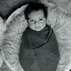 A striking black and white portrait. This simple, swaddled pose becomes incredibly powerful in monochrome, highlighting the baby's beautiful eyes and features.