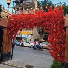 The entrance to the Navjote ceremony, where a stunning arch made of bright red flowers makes a bold statement. This creates a festive welcome right from the street, signaling a joyous celebration within.