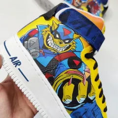 A hand-held shot showing the vibrant colors and clean line work on the SWAT Kats Nike Air Force 1s. This is pure nostalgia in the form of wearable art.