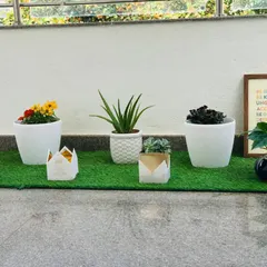 This section of the balcony features smaller plants, including flowering marigolds and succulents in unique geometric pots. It shows how you can mix and match different sizes and styles to create a dynamic and personal garden.