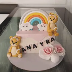A beautiful cake featuring two teddy bears, a rainbow, and fondant roses. The soft pastel colors make this a perfect choice for a baby shower or first birthday.