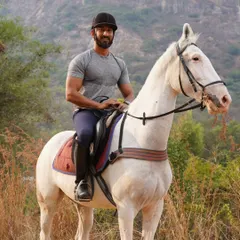 A rider posing proudly on his white horse against a stunning mountain backdrop during one of our safari trips. These are the moments that make it all worthwhile.
