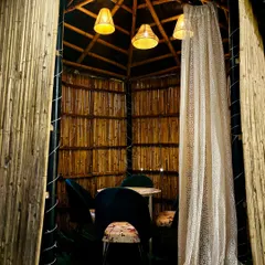 Step inside one of my cozy bamboo huts. With its rustic charm and intimate seating, it's the perfect little haven for private conversations.