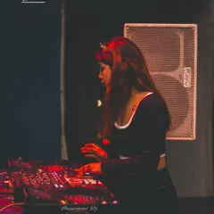 A side view of my setup at the private techno party. It shows my focus on the mixer, crafting the sound for an exclusive audience.
