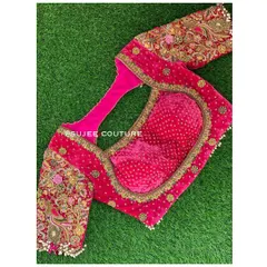 The front view of the pink velvet blouse, showing the sweetheart neckline and the heavily embroidered sleeves. The inside features a contrasting bandhani print lining for a hidden detail.