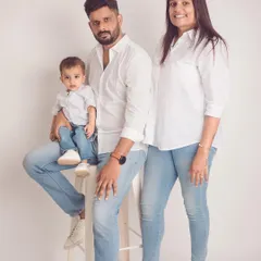 The perfect example of a classic family photo. The coordinated white shirts and denim create a clean, bright, and timeless look against a simple studio backdrop.
