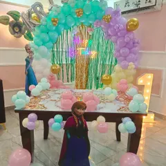 First birthday ke liye ek aur Frozen theme decoration. Ismein humne pastel green aur purple balloons, Anna aur Elsa ke cutouts, aur '1' number ka light wala letter lagaya hai.