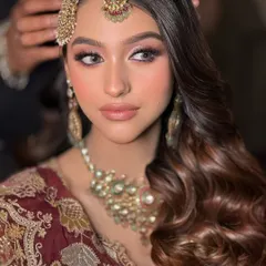 A close-up of this bride's soft glam makeup. The focus is on the beautifully blended eyeshadow, rosy cheeks, and a perfect nude lip.