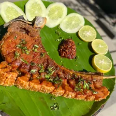 A full rack of our crispy pork ribs with the skin on, seasoned with Naga flavors. The scored skin becomes incredibly crunchy, offering a perfect contrast to the juicy meat underneath.