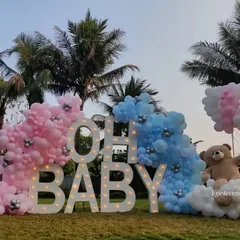 Make a big statement with an outdoor celebration. For this gender reveal, we used large, illuminated "OH BABY" marquee letters flanked by pink and blue organic balloon clouds. This setup creates a spectacular photo opportunity and focal point for your event, day or night.