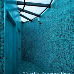 A detail shot of the curved mosaic-tiled bathroom, emphasizing the tactile quality of the tiles and the way the skylight above creates a dynamic interplay of light and shadow.