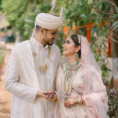 A quiet, romantic moment between the couple. The bride's pastel lehenga and emerald jewelry are complemented by a soft glam makeup look that enhances her natural beauty.