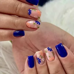 A striking combination of bold and delicate. This set features glossy, solid royal blue nails paired with accent nails that have a sheer base and are covered in pretty blue and white floral patterns.