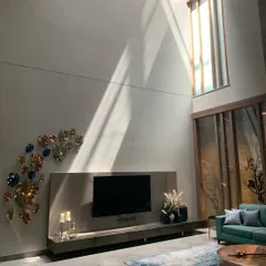 Light is a key element in my work. Here, a beam of sunlight cuts across a double-height living room, highlighting the texture of the wall and bringing the space to life.