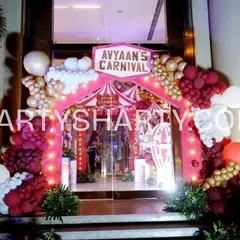 The entrance to 'Avyaan's Carnival', framed by a balloon arch in red, white, and gold, setting the stage for a fun-filled celebration.