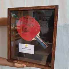 The autographed TT paddle, securely mounted inside its custom-made wooden shadow box, ready to be presented as a thank you gift.