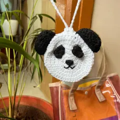 A clear shot of our handmade crochet panda pouch, showing the detailed face and ears. It comes with a string to hang from your bag.