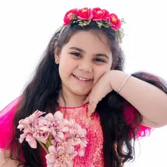 Sparkle in her dress, magic in her eyes. This close-up portrait captures the sweet, happy spirit of this young girl.