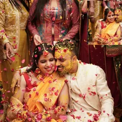 The Haldi ceremony is all about unrestrained joy. We love capturing these candid moments of celebration, like this one where the couple is showered with flower petals, creating a memory filled with laughter and color.