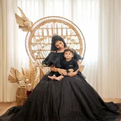 A stunning portrait of a mother and her child in our boho-themed studio setup. The mother is wearing our dramatic black ballgown.