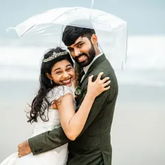 A candid moment of happiness during a rainy Goa photoshoot. The genuine smiles and warm embrace under the umbrella show that even a little rain can't dampen the joy of the day.