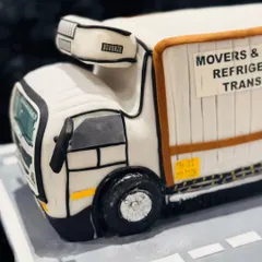 A side view of a hyper-realistic truck cake I created for a business owner. The details, like the tires and the text on the side, are all meticulously crafted from edible materials.