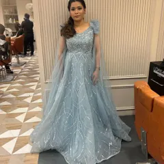 A happy client looking like she stepped out of a fairytale in this powder blue sequined gown. It's the perfect rental for a reception or engagement party.